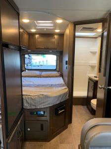 ein kleines Schlafzimmer mit einem Bett in einem Wohnwagen in der Unterkunft AJ-XL RV Rental in Reseda