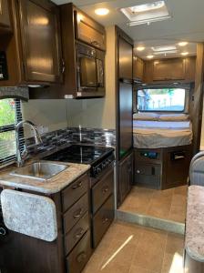 een keuken in een camper met een wastafel en een bed bij AJ-XL RV Rental in Reseda