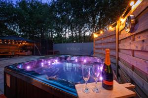 a hot tub with two glasses and a bottle of wine at The island life Texel - Wellness in De Koog