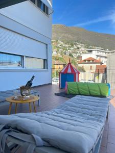 een groot bed op een balkon met een tafel en een tent bij Casa Kromatica in Locarno