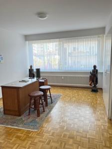 een lege kamer met een bureau en krukken in een kamer met ramen bij Casa Kromatica in Locarno