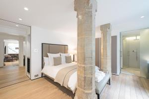 a bedroom with a large bed and a large column at Knightsbridge Large Luxury Flat With Outside Space in London
