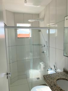 a bathroom with a shower and a toilet and a sink at Sol de Bora Bora 101 in Salvador