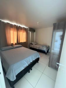 1 dormitorio con 1 cama grande, 1 cama y ventana en Sol de Bora Bora 101, en Salvador
