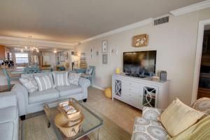 een woonkamer met een bank en een tv bij El Matador 347 - Beautiful views of the Gulf and pool in Fort Walton Beach