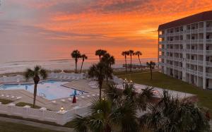 een uitzicht op een hotel en de oceaan bij zonsondergang bij El Matador 347 - Beautiful views of the Gulf and pool in Fort Walton Beach