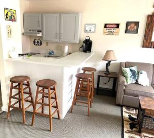 a kitchen with a counter and stools in a living room at Unique Yeti-Theme Ski On Off Suite Jiminy-Sleeps 4 in Hancock