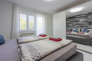 twee bedden in een witte kamer met twee bedden bij House Moderna 2 in Crikvenica