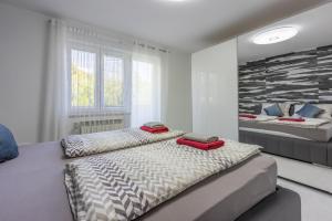 two beds in a white room with two beds at House Moderna 2 in Crikvenica