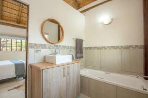 マールロス・パークにあるEye of Kruger - Spacious holiday home with splash pool and bomaの洗面台、浴槽、鏡のあるバスルーム +14枚の写真