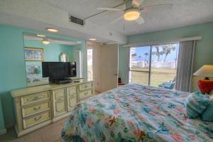 um quarto com uma cama e uma televisão de ecrã plano em El Matador 416 - Walk right out to the pool and the beach! em Fort Walton Beach