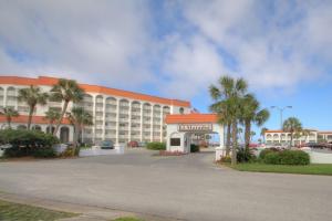 un grand bâtiment avec des palmiers devant lui dans l'établissement El Matador 437 - Gulf front with beautiful views of the Gulf and pool, à Fort Walton Beach