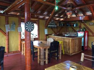 a dining room with a table and a bar at Hotel Campestre Los Tucanes in Armenia