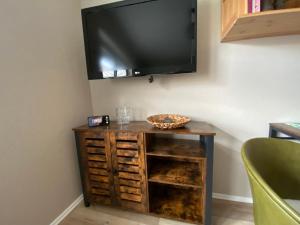 a television on a wall above a wooden table at Lagerhaus Gabriel in Zweibrücken