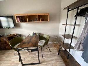 Zimmer mit einem Holztisch und grünen Stühlen in der Unterkunft Lagerhaus Gabriel in Zweibrücken