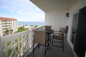 een balkon met een tafel en stoelen en de oceaan bij El Matador 461 - Beautiful views of the pool and Gulf of Mexico in Fort Walton Beach