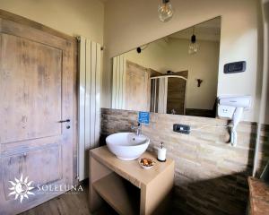 łazienka z umywalką i dużym lustrem w obiekcie AFFITTACAMERE SOLE & LUNA w mieście Capovalle
