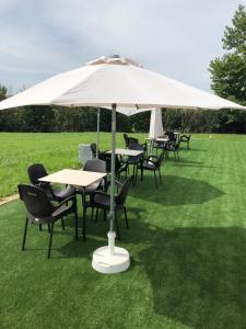 a group of tables and chairs under an umbrella at Hotel Villa de los Arcos in Los Arcos