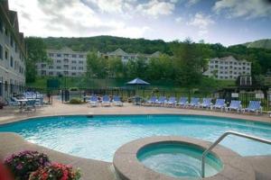 una gran piscina con sillas y un edificio en Ski On Off 1BR Suite 1st Flr Sleeps 4 Jiminy Peak, en Hancock