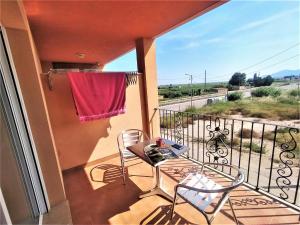 a balcony with two chairs and a table and a window at Lo Petit Delta in El Lligallo del Gànguil
