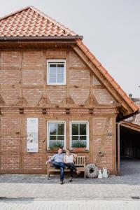 a man and woman sitting on a bench in front of a building at Holzmichel 