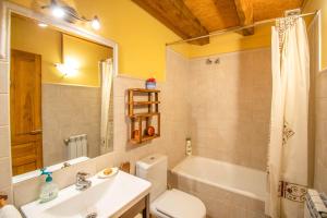 a bathroom with a sink and a toilet and a tub at Casa Monaut, acogedores apartamentos a los pies de la selva de Irati in Saragüeta