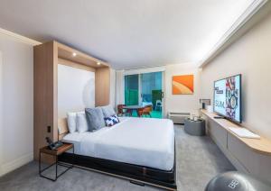 a bedroom with a large white bed and a desk at BEI San Francisco, Trademark Collection by Wyndham in San Francisco