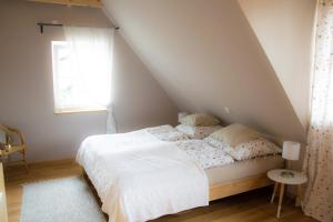 a bedroom with a white bed in a attic at Holzmichel in Hullern