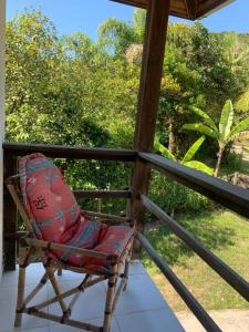 un fauteuil à bascule assis sur la terrasse couverte d'une maison dans l'établissement Guesthousebr, à Bombinhas