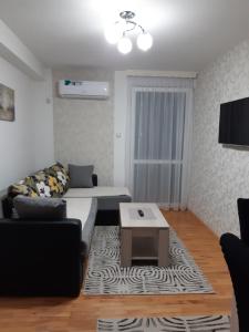 uma sala de estar com um sofá e uma mesa de centro em Apartman Park em Zvornik