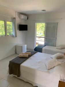 a bedroom with two beds and a flat screen tv at Guesthousebr in Bombinhas