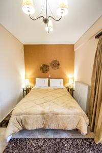 a bedroom with a large bed and two lamps at Enastron in Kalavrita