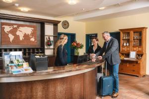 a man standing at a counter in a hotel lobby at Hotel am Park in Hückelhoven