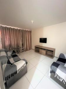 a bedroom with two beds and a flat screen tv at Sol de Bora Bora 103 in Salvador