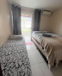 a bedroom with two beds and a window at Sol de Bora Bora 103 in Salvador