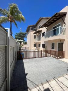 una casa con una valla y una palmera en Sol de Bora Bora 103, en Salvador