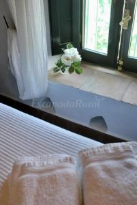 um quarto com uma cama e uma janela com uma flor em Finca La Vicaria PALOMAR em Zufre