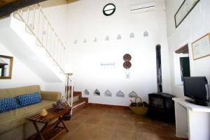 uma sala de estar com um sofá e uma lareira em Finca La Vicaria PALOMAR em Zufre