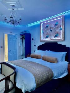 1 dormitorio azul con 1 cama grande y una pintura en la pared en The Gatsby Blackpool - Formerly The Windsor, en Blackpool