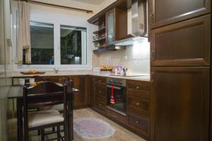 kuchnia z drewnianymi szafkami, stołem i kuchenką w obiekcie Woods cottage Loutra Pozar Aridaia w mieście Megaplátanos