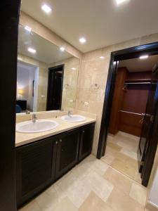 a bathroom with two sinks and a large mirror at Karibo Punta Cana in Punta Cana