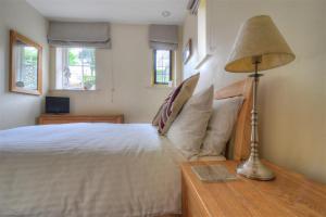 1 dormitorio con 1 cama y 1 lámpara en una mesa en Coram Lodge, en Lyme Regis