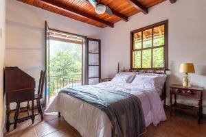 a bedroom with a bed and a window at CurtaTere piscina lareira pet friendly jardim in Teresópolis +64 photos