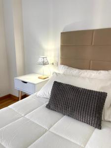 Filo Guest House في بيروجيا: سرير عليه وسادة سوداء وبيضاء