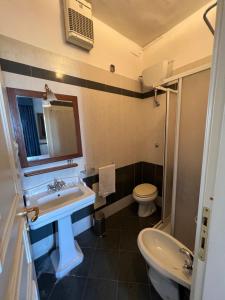 bagno con lavandino, servizi igienici e specchio di Villa Edelweiss a Bacoli