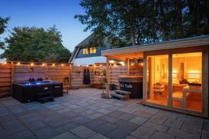 un patio al aire libre con un bar y una casa en The island life Texel - Wellness, en De Koog
