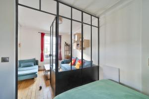 um quarto com um grande armário espelhado e um sofá azul em Comfortable apartment in the heart of Paris - Welkeys em Paris