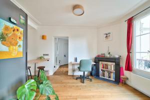 een woonkamer met een bureau en een stoel bij Comfortable apartment in the heart of Paris - Welkeys in Parijs