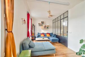 uma sala de estar com um sofá azul e uma mesa em Comfortable apartment in the heart of Paris - Welkeys em Paris