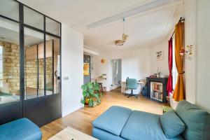 een woonkamer met een blauwe bank en een tafel bij Comfortable apartment in the heart of Paris - Welkeys in Parijs